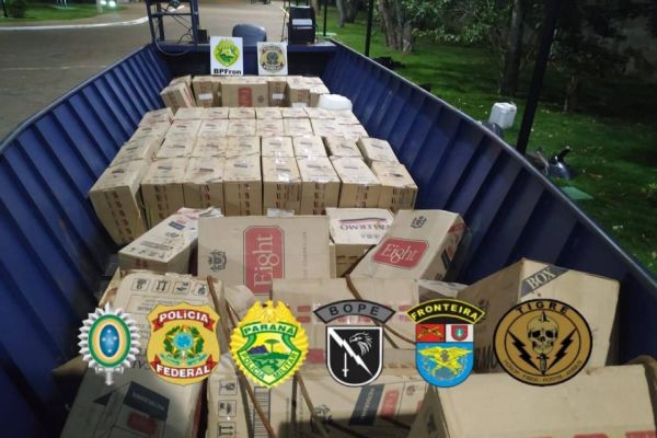 Policiais realizam a apreensão de embarcações, caminhão carregado com caixas de cigarro