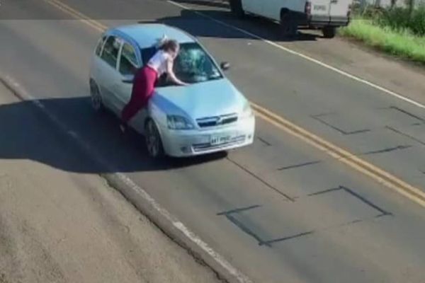Imagem referente a notícia: Câmeras flagram mulher sendo transportada em capô de veículo após briga com o ex-companheiro