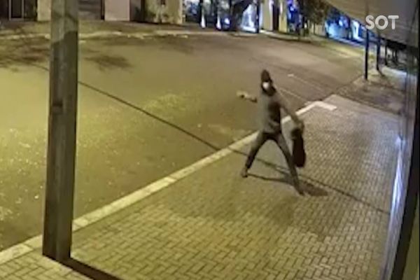 Imagem referente a notícia: Câmera de segurança registra homem jogando paver em vidraça de loja na Rua Pernambuco