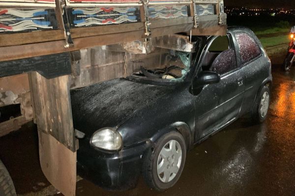 Imagem referente a notícia: Corsa para de baixo do caminhão e motorista fica ferido na Avenida das Pombas no Jardim Clarito