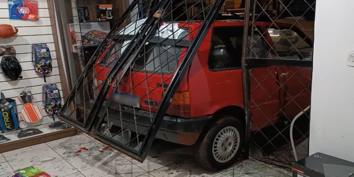 Gangue da Marcha à Ré: Fiat Uno fica entalado na porta de loja e bandidos fogem sem levar nada