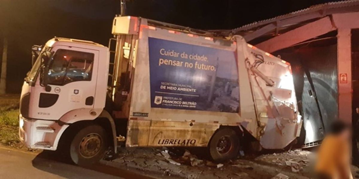 Coletor fica ferido após caminhão da coleta de lixo colidir em barracão
