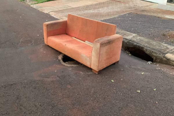 Imagem referente a notícia: Moradores utilizam sofá para sinalizar “tampa de boca de lobo” quebrada no Bairro Periolo