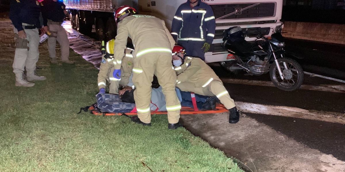 Moto fica presa em caminhão após colisão traseira na BR-277, em Cascavel